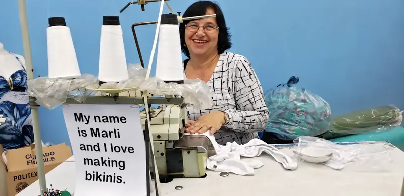 Marli smiling at her sewing machine in the Mar Egeu workshop